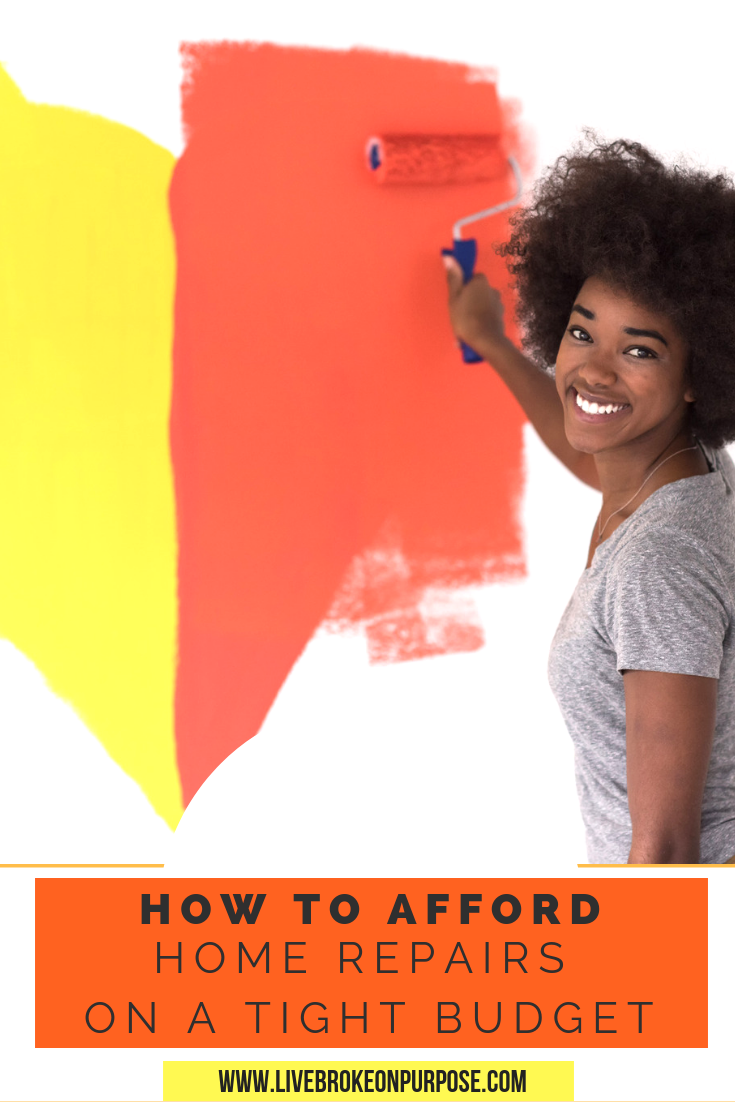 African american girl painting wall yellow and orange.